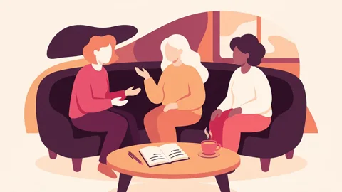 Three fully clothed adults sit in a circle on a couch, talking calmly; a notebook, pen, and tea cup are on the table in front of them.
